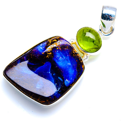 Sterling silver pendant featuring blue boulder opal with green peridot accents in bail