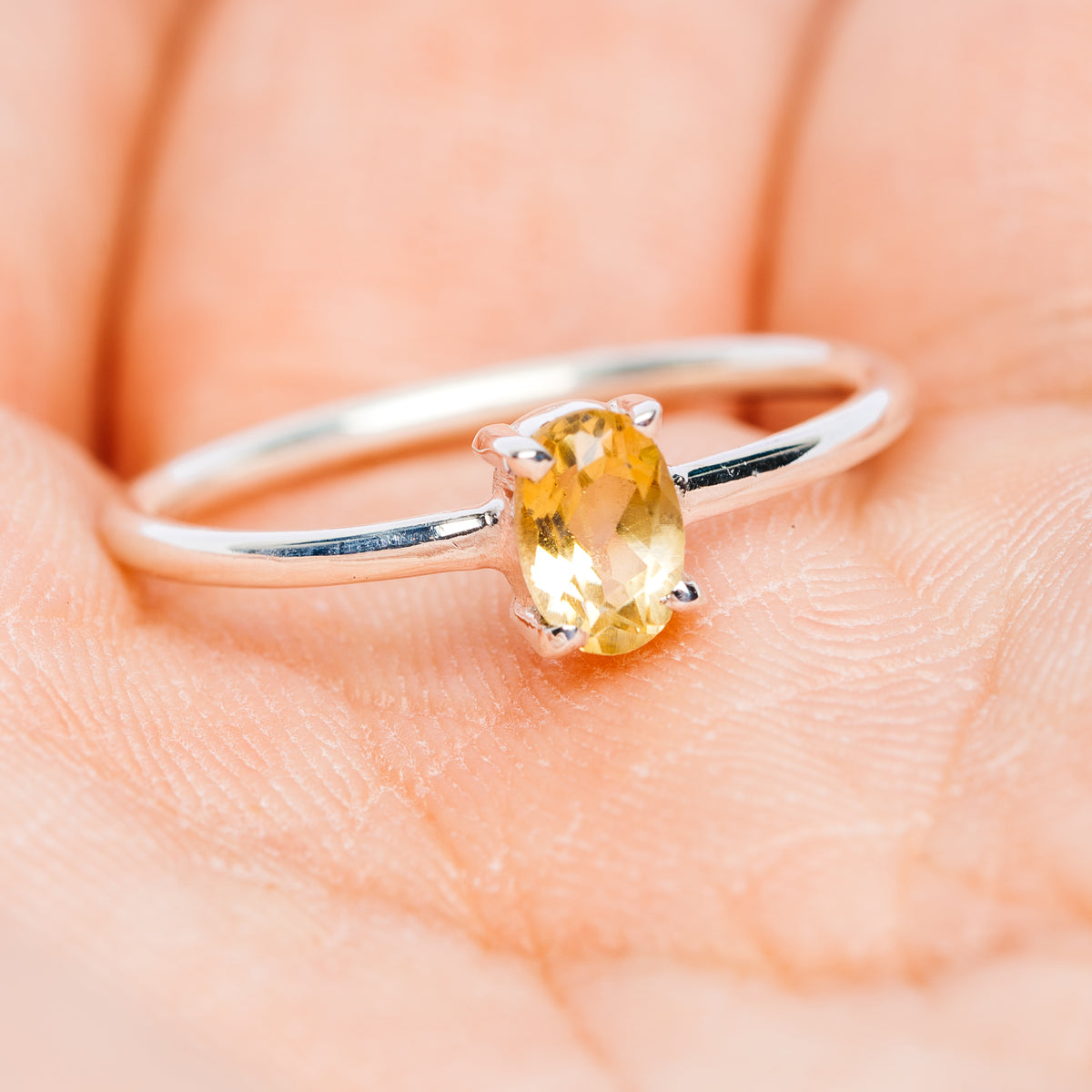 Oval citrine gemstone stackable sterling silver ring on slim band, side view