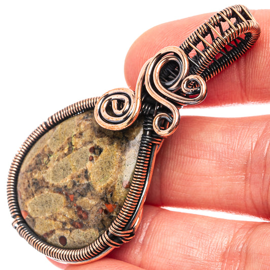 Peanut obsidian wire wrap pendant with oxidized copper coils and oval dark stone