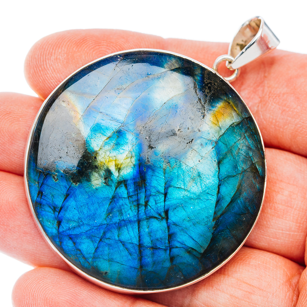 Round sterling silver spectrolite pendant with iridescent blue cabochon and bail