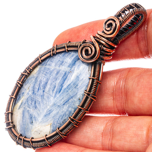 Kyanite wire wrap pendant with oval blue stone, oxidized copper spiral wire frame