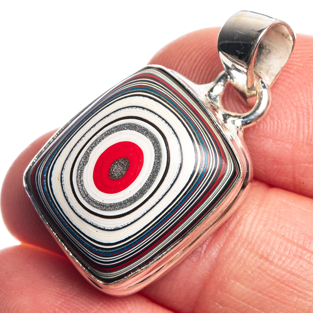 925 sterling silver pendant, striped swirl design with red center, close-up on finger