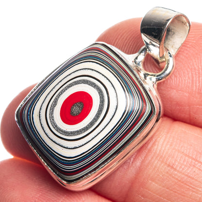 925 sterling silver pendant, striped swirl design with red center, close-up on finger