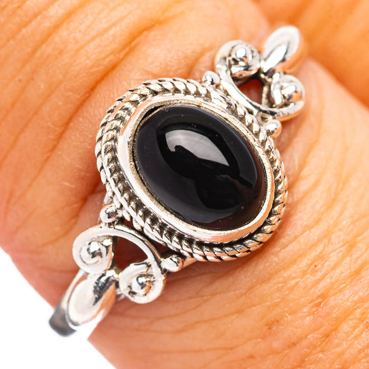 Sterling silver ring with black onyx oval centerpiece and ornate rope-like bezel