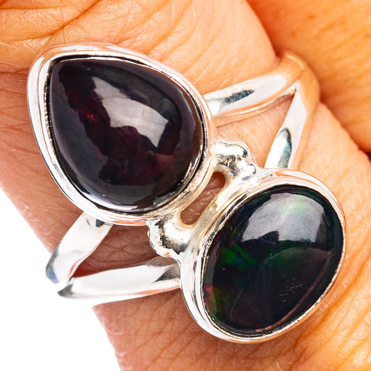 Sterling silver opal ring with two dark oval cabochons, one showing green flashes