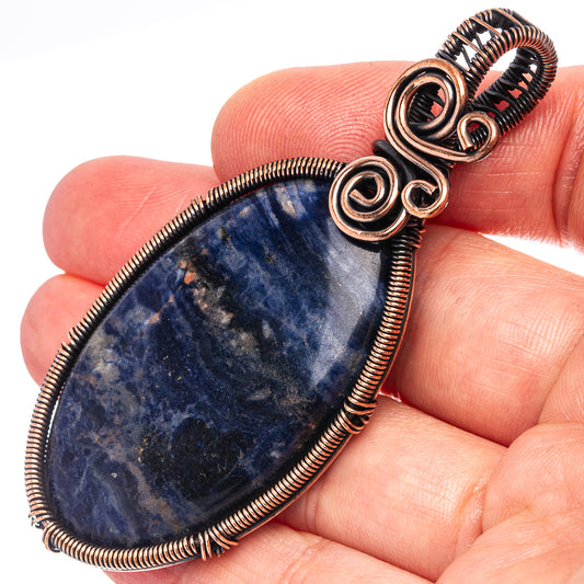 Oxidized copper wire-wrapped teardrop sodalite pendant with spiral top loops