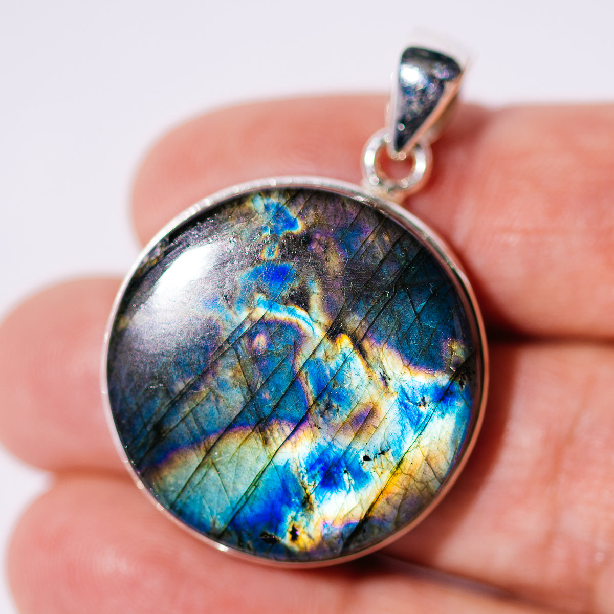 Round Spectrolite pendant in a sterling silver bezel, with vivid blue, gold, and green flashes