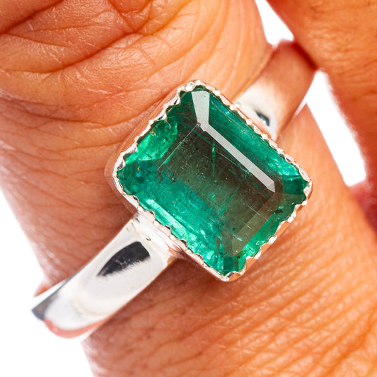 Sterling silver ring with faceted green emerald in ornate bezel setting