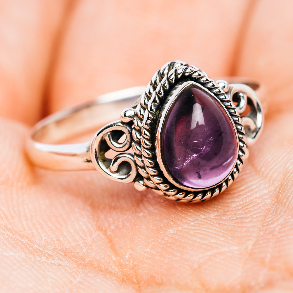 Oval amethyst ring in .925 sterling silver, twisted border and decorative side scrolls