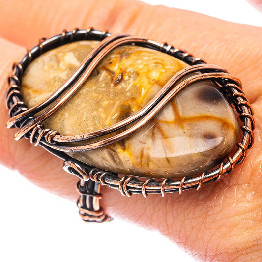 Oxidized copper wire wrap ring with oval amber-brown stone and dark beaded wire border