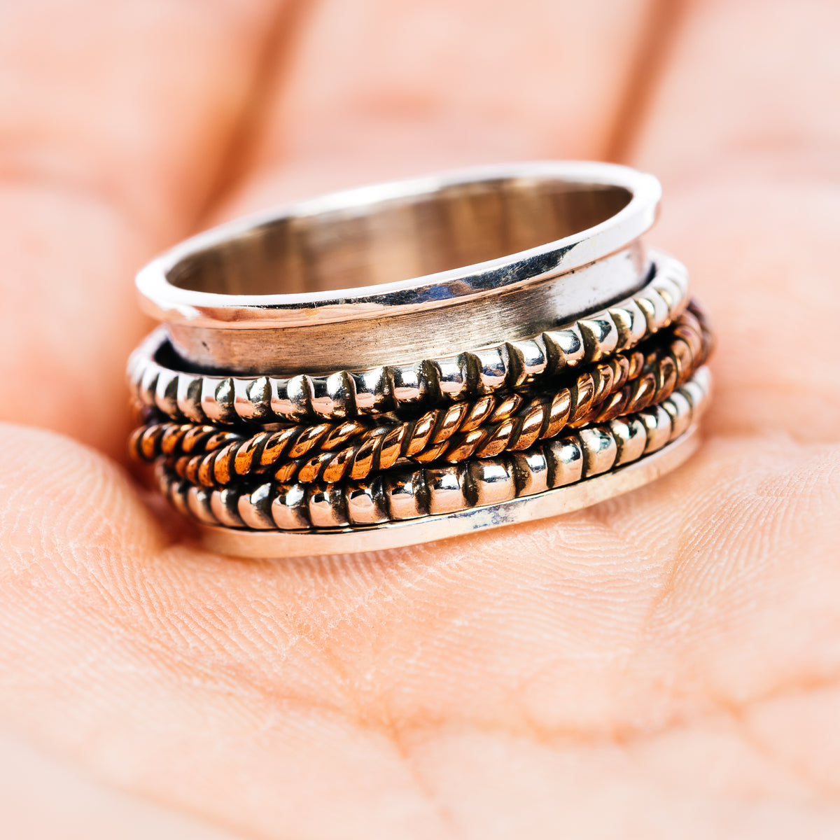 Sterling silver spinner ring with smooth band and twisted ridged grooves