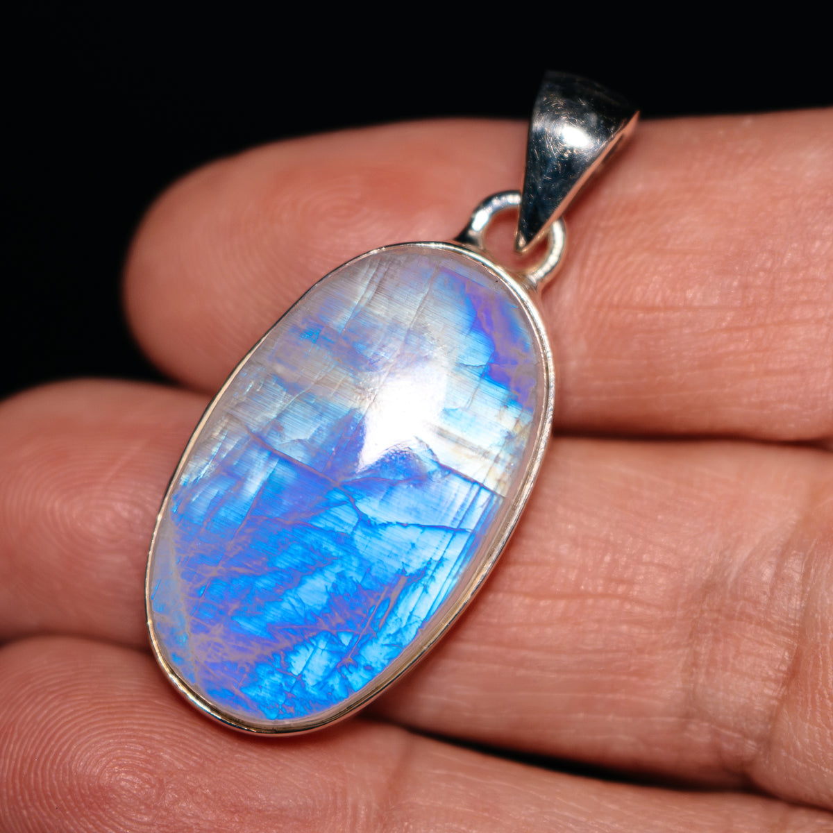 Oval rainbow moonstone pendant in .925 sterling silver bezel, with silver bail