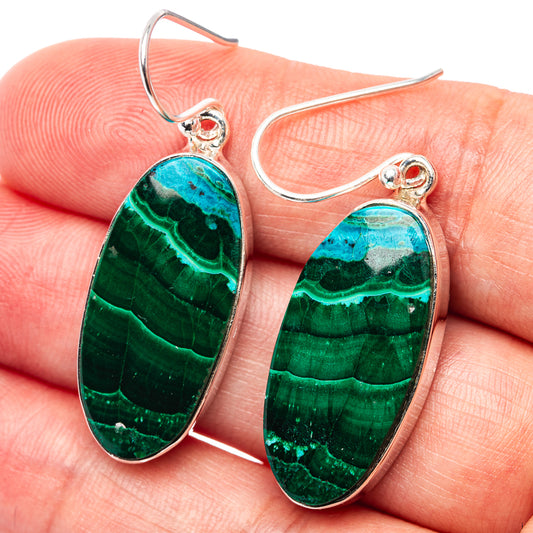 Close-up oval malachite-chrysocolla earrings with sterling silver hooks and green-blue stone