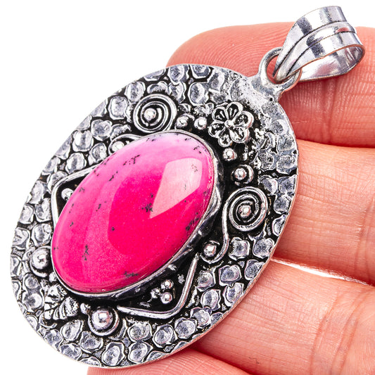 Pink oval opal pendant with ornate silver-tone filigree and loop bail