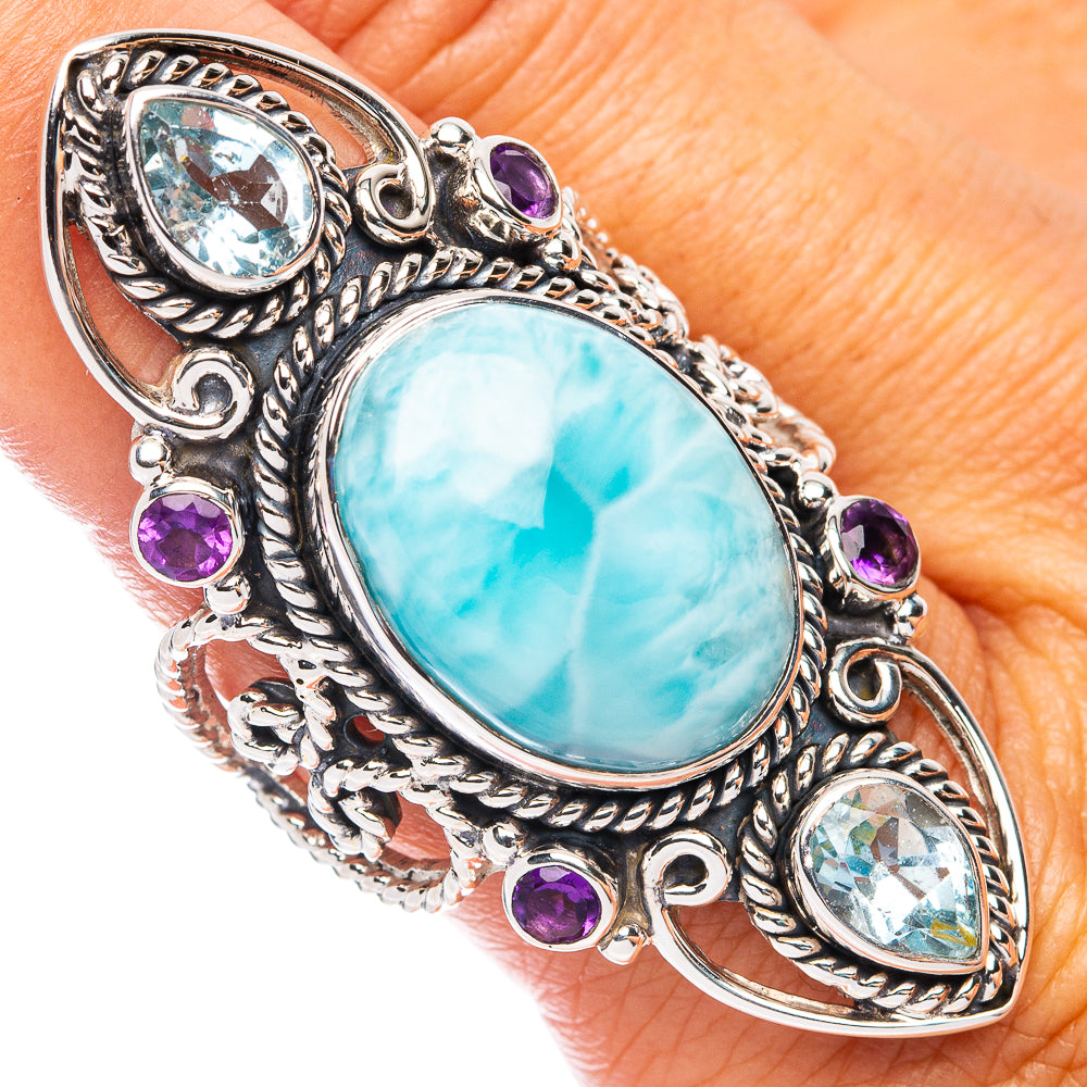 Sterling silver ornate oval gemstone ring with light blue center and purple accent stones