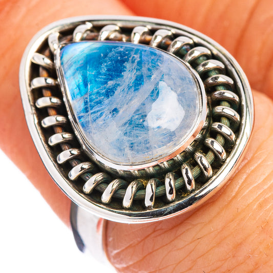 Sterling silver moonstone ring on finger, oval blue stone with scalloped bezel