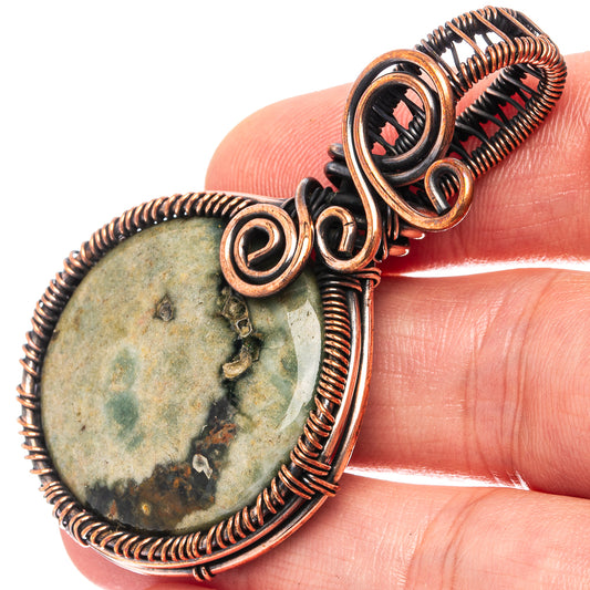 Ocean jasper wire wrap pendant with oval green mottled stone, oxidized copper spirals