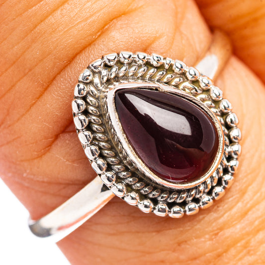 Sterling silver garnet oval ring with dark red cabochon and ornate bead border
