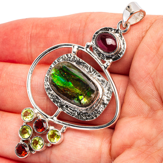 Sterling silver pendant with green iridescent oval, red gemstone cap, peridot cluster