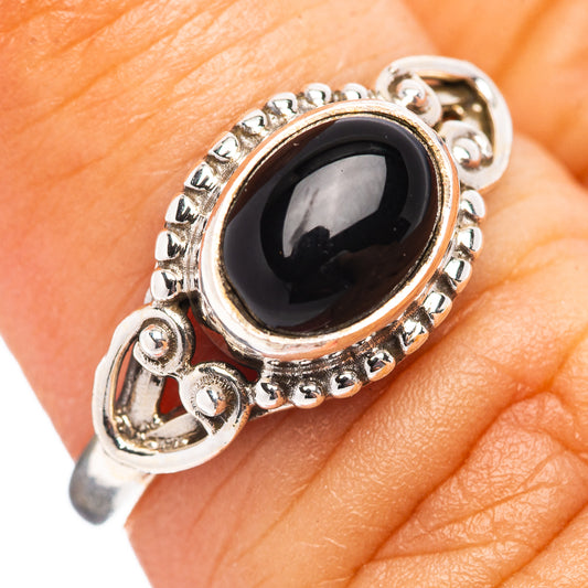 Sterling silver ring with oval black onyx, small round halo and ornate prongs