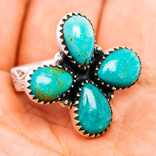 Turquoise oval stones ring with dark metal floral setting, silver band visible