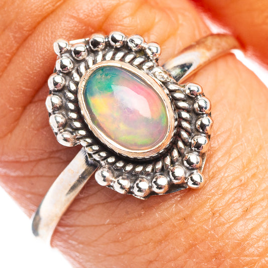 Sterling silver opal ring detail: oval multicolor cabochon in ornate beaded bezel.