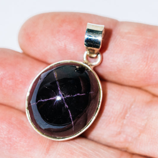 Round sterling silver star garnet pendant with dark purple star cabochon bail