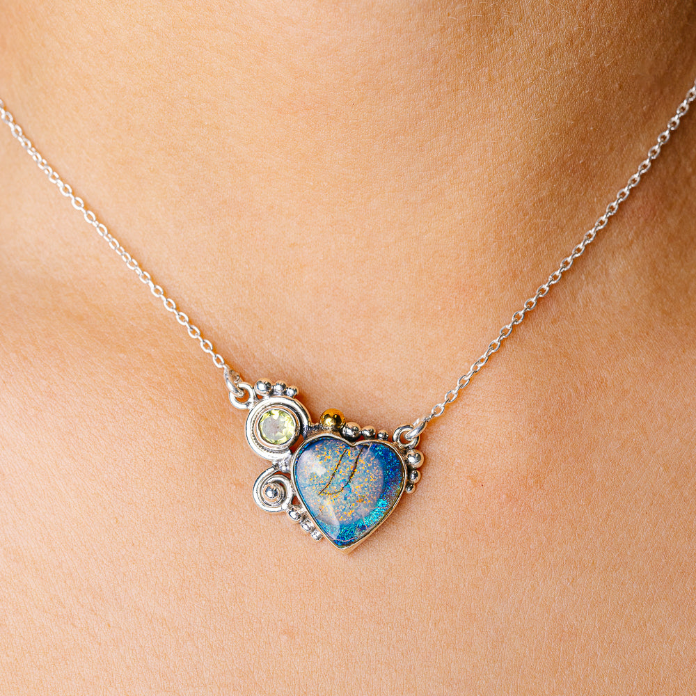 Sterling silver necklace with heart-shaped blue opal pendant and small gold accents