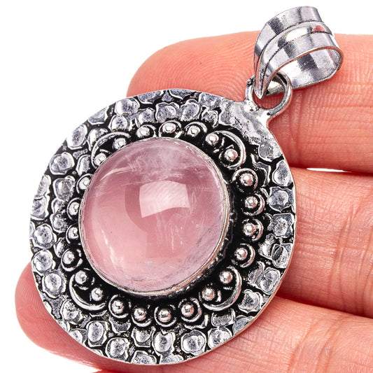 German silver round pendant with ornate bezel and pink rose quartz cabochon