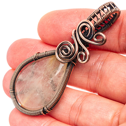 Oxidized copper wire wrap rutilated quartz teardrop pendant close-up, spiral rings