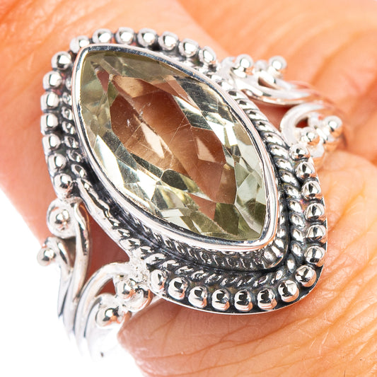 Sterling silver ring with oval greenish gemstone and beaded halo setting