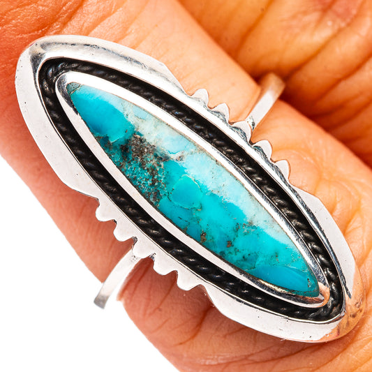 Turquoise oval ring with black bezel and scalloped sterling silver edges, close-up