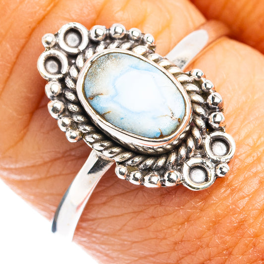 Turquoise oval cabochon sterling silver ring with ornate beaded bezel on finger