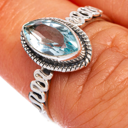Oval blue gemstone bezel on ornate sterling silver ring with textured band