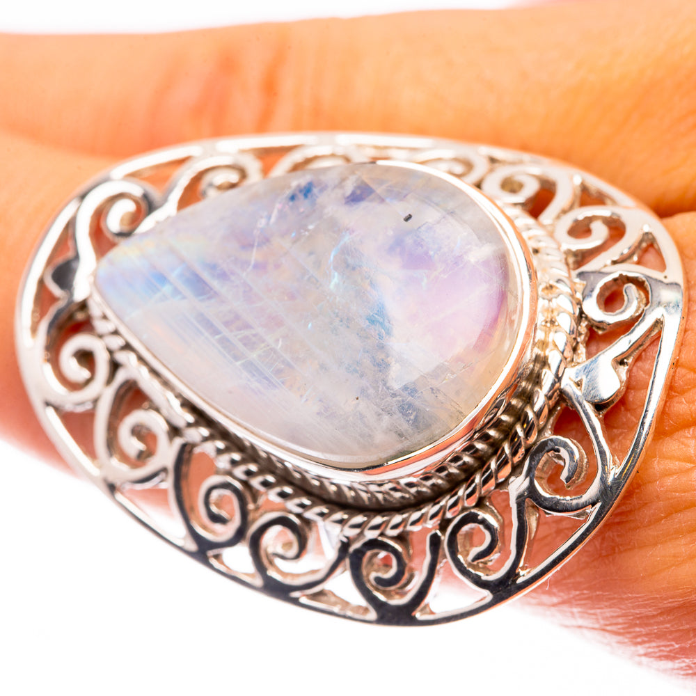 Silver oval moonstone ring with ornate filigree setting and iridescent rainbow sheen