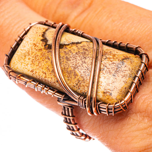 Oxidized copper ring with picture jasper cabochon on finger, tan stone with dark patches