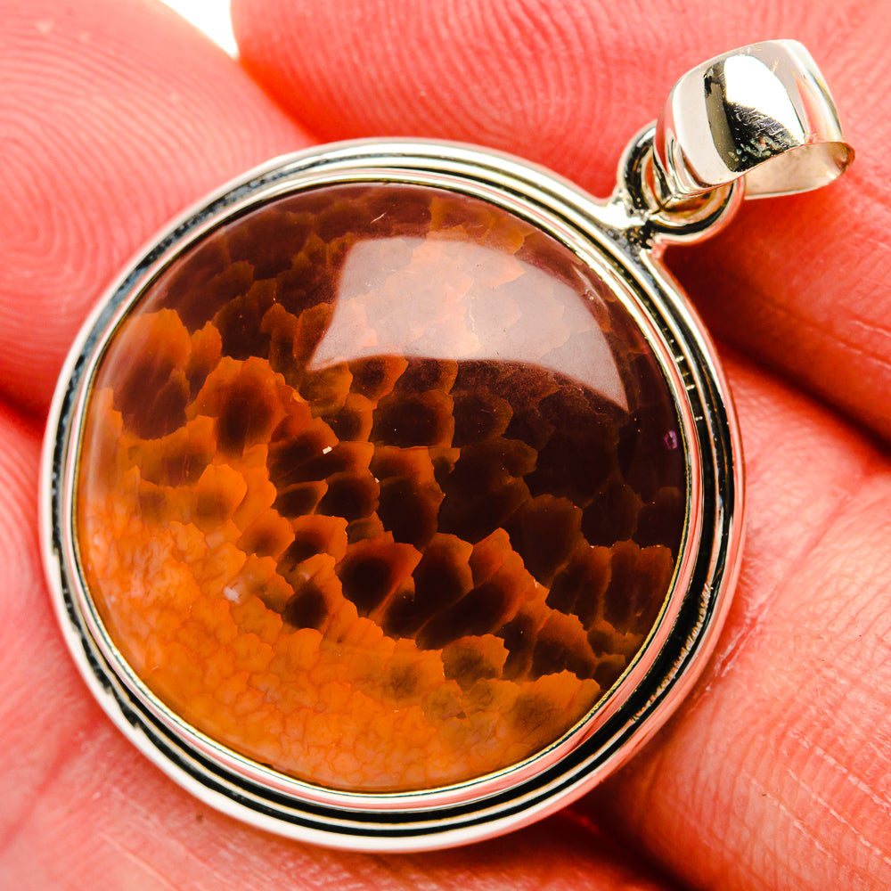 Round orange fire agate pendant in sterling silver bezel with textured bail