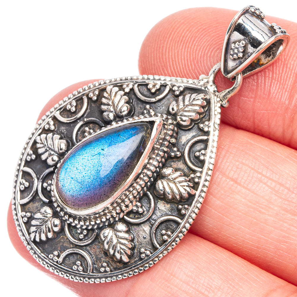 Teardrop labradorite pendant with ornate silver-tone filigree and bail, blue flash.