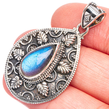 Teardrop labradorite pendant with ornate silver-tone filigree and bail, blue flash.