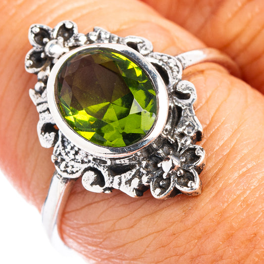 Sterling silver ring with round green gemstone and detailed floral filigree setting