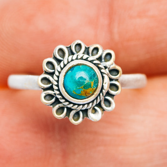 Turquoise oval cabochon ring with detailed silver rosette setting