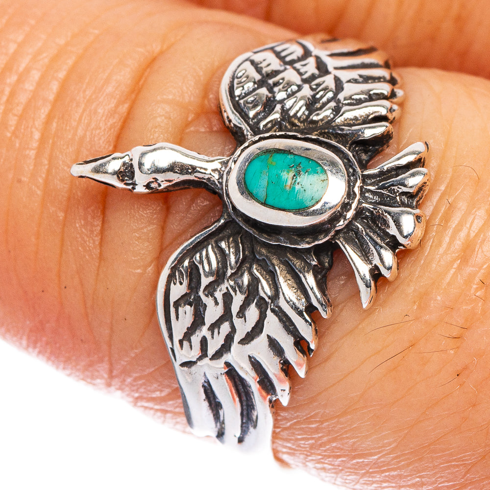 Turquoise oval bird ring close-up on finger, silver-tone wings and carved feather detail