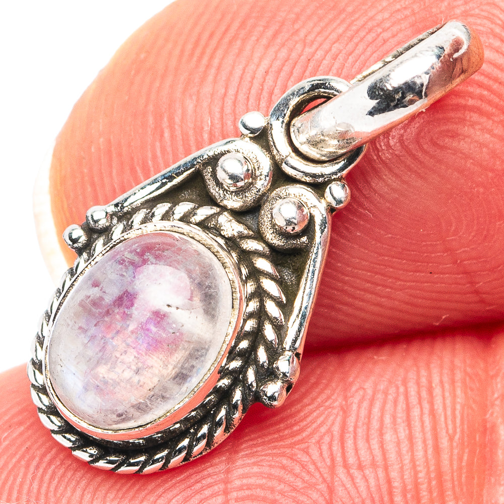 Sterling silver oval rainbow moonstone pendant with ornate filigree setting, close-up
