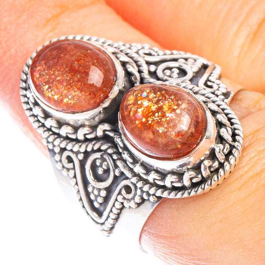 Sterling silver ring with two oval sunstone cabochons and ornate engraved settings