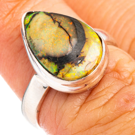 Sterling silver ring with oval green-orange opal cabochon in a curved bezel