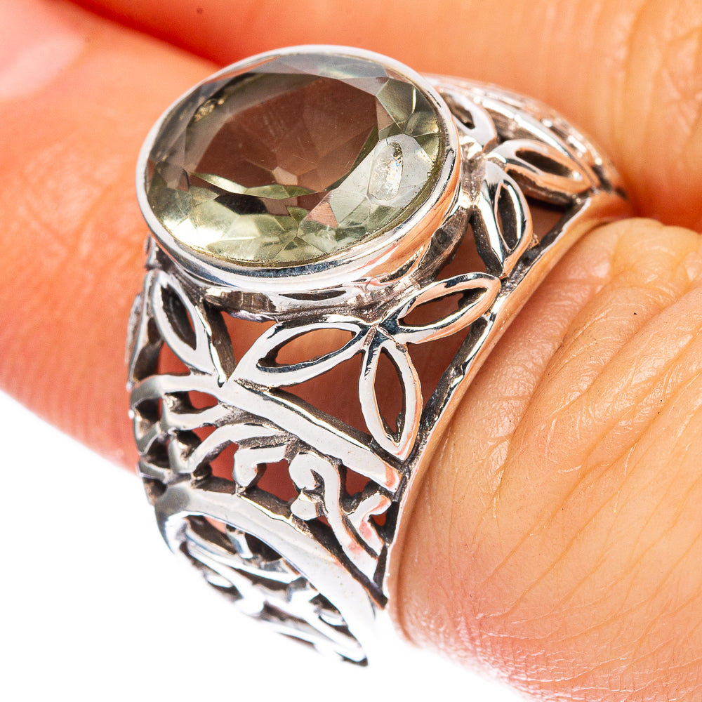 Sterling silver ring with ornate filigree and faceted green gemstone, oval setting