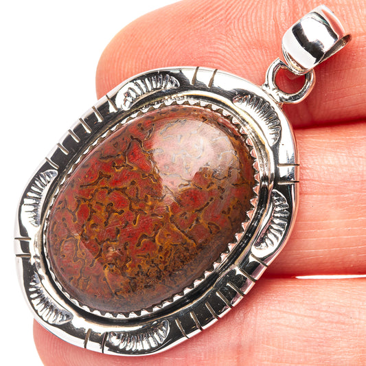 Dinosaur bone pendant in oval cabochon with red and brown stone, sterling silver setting