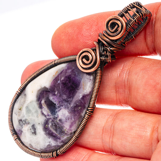 Amethyst wire wrap pendant close-up on teardrop stone and oxidized copper coils