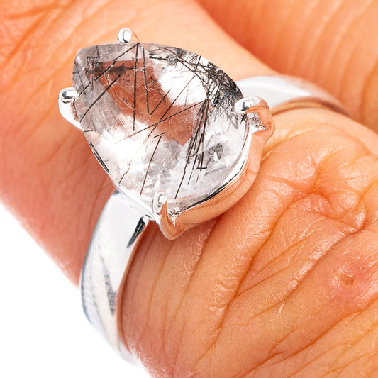 Sterling silver ring with faceted tourmalinated quartz stone and prongs, worn on finger.
