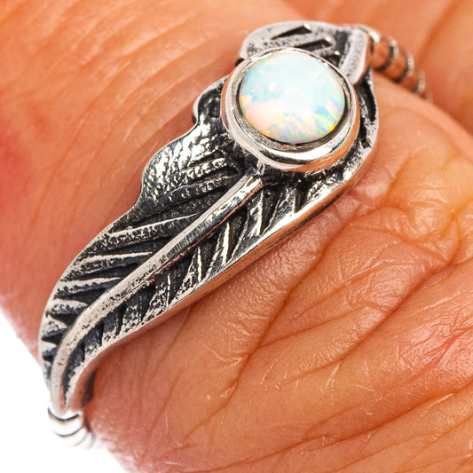 Sterling silver feather ring close-up with iridescent round opal lab-created stone
